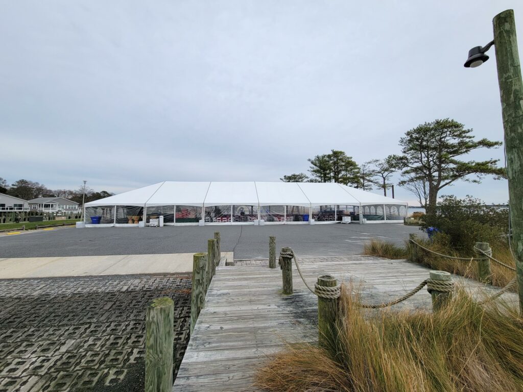 large frame tent installed on parking lot for community holiday party.