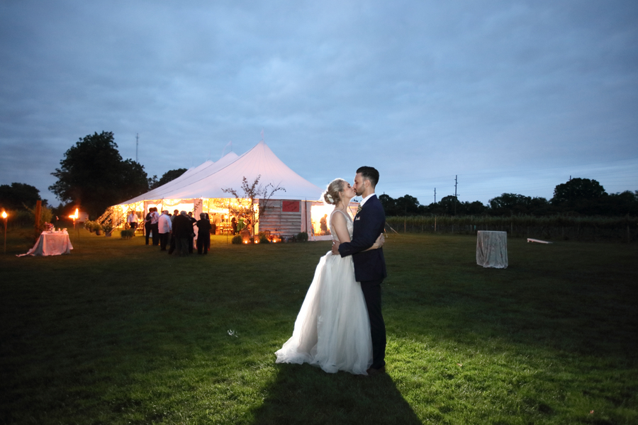 bride and groom photo at dusk in front of wedding tent