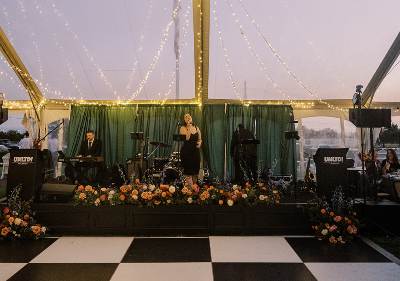 corporate_staging Band stage behind a black and white dance floor under a cleartop tent