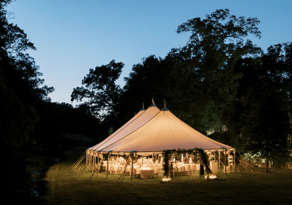 Glowing sailcloth tent at night for an outdoor wedding by Collective Event Group