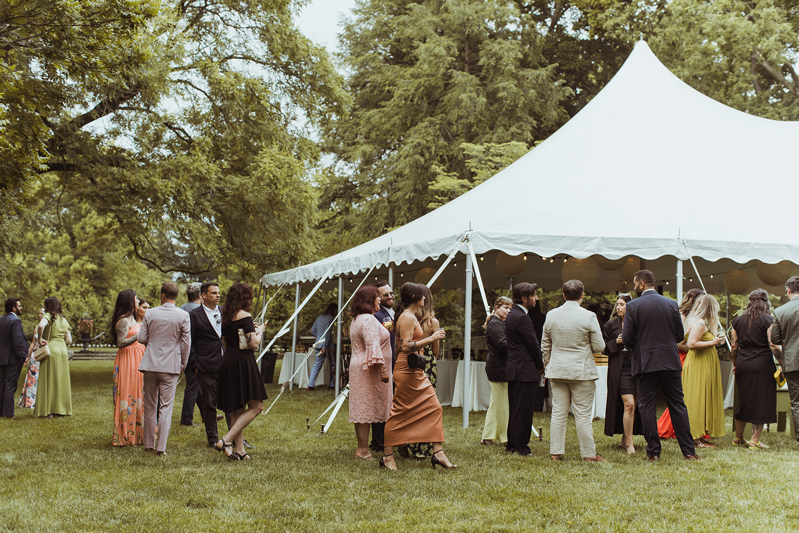 high peak pole tent on grass with people standing outside