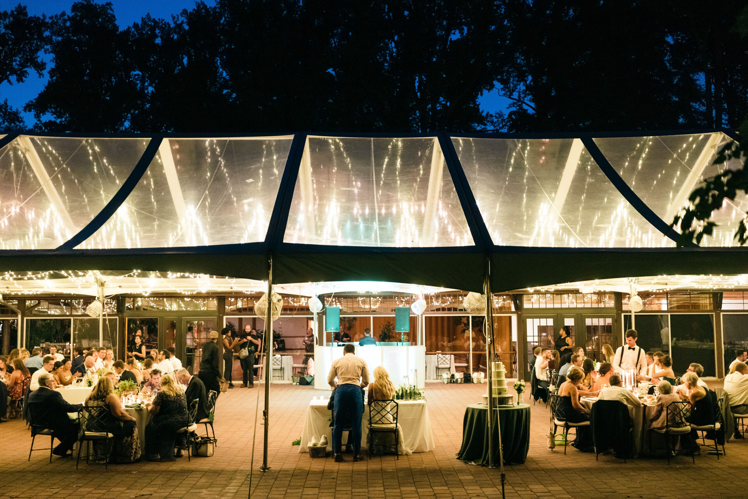 clear top wedding tent photo with twinkle lights glowing thru the tent top