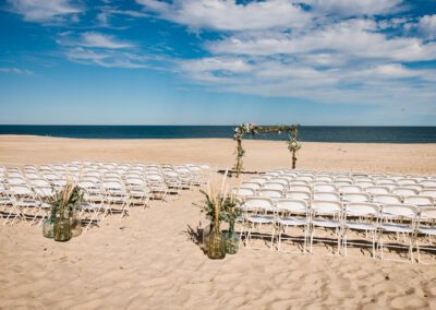 white folding chairs set up in rows on a beach for wedding ceremony in Delaware