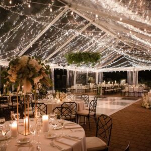 Clear top frame tent with Galaxy Lighting set up for a wedding over a patio with black and white checkered dance floor