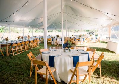 Round tables with wooden folding chairs by Collective Event Group for a fall wedding at Adkins Arboretum