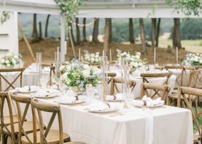 clear top tent with tables with white linen and cross back chairs