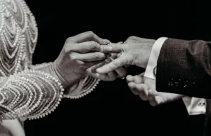 black and white photo of bride and groom doing ring exchange