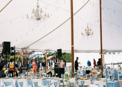 wedding tent with white tuscan bistro lighting and chandeliers on sand