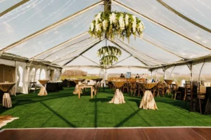 clear top tent wedding interior with flooring and floral chandeliers