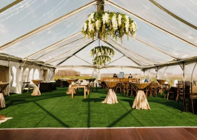 clear top tent wedding interior with flooring and floral chandeliers