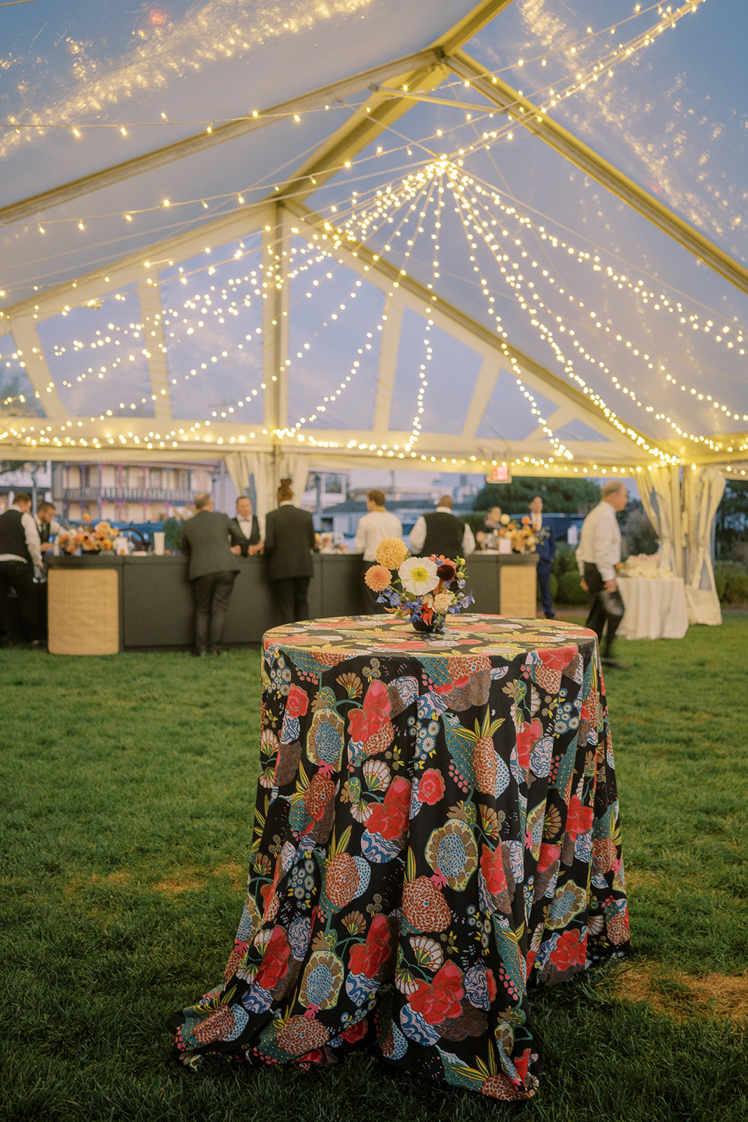 clear tent with twinkle lights, table with floral linen