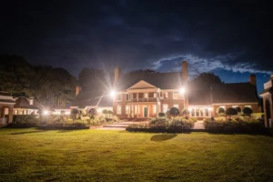 brick mansion at dusk with outdoor lighting