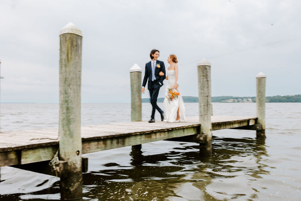 Bride and Groom walking on a private dock for their wedding portraits by Philter Photography