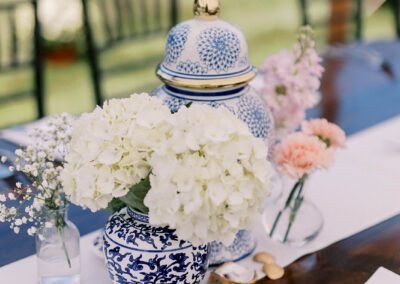 table with blue vase and white hydrangea floral center piece