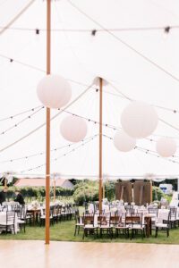 wedding tent interior showing dance floor and black chairs
