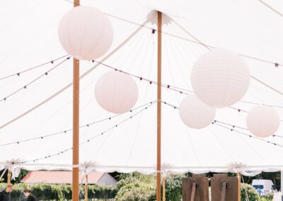 wedding tent interior showing dance floor and black chairs