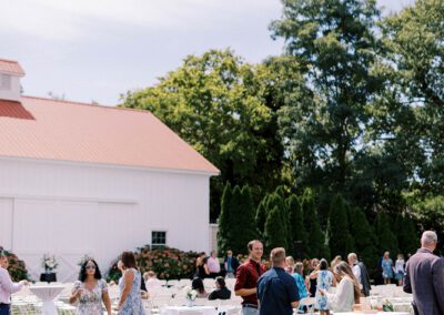 outdoor cocktail hour on grass in front of white barn