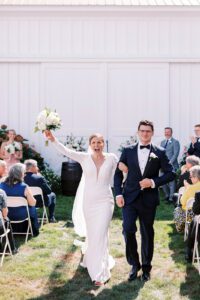 bride and groom just married walking down aisle cheering
