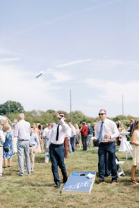 playing corn hole during wedding cocktail hour on summer day
