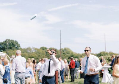 playing corn hole during wedding cocktail hour on summer day