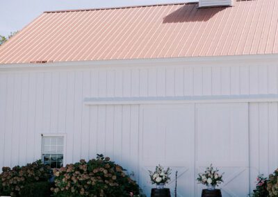 white ceremony chairs set up in front of barn