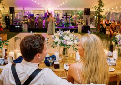 bride and groom seated at head table overlooking their wedding reception