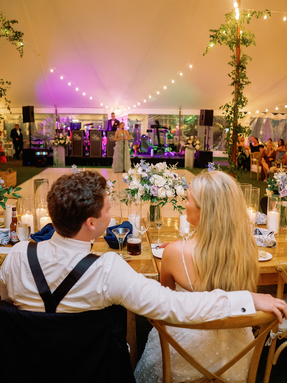 bride and groom seated at head table overlooking their wedding reception