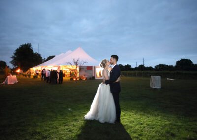 bride and groom photo at dusk in front of wedding tent
