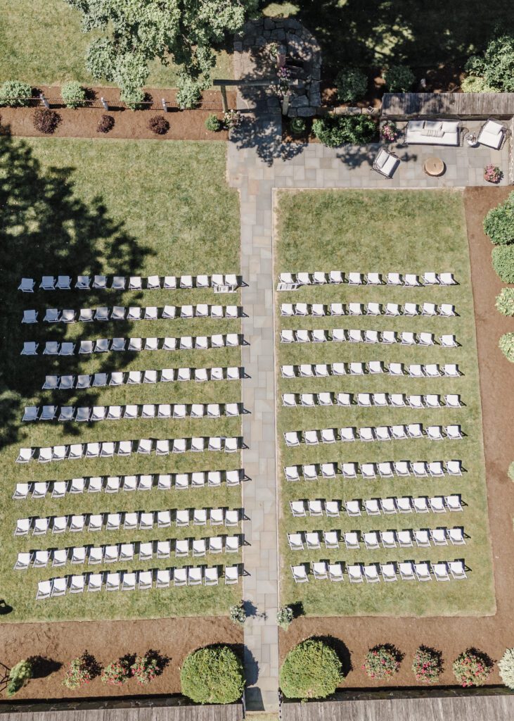 white chairs lined up on grass for outdoor wedding ceremony