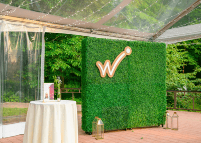 Westside logo backdrop next to a cocktail table underneath a cleartop tent