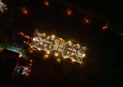 Drone aerial view of a 40x120 cleartop tent light up at tent