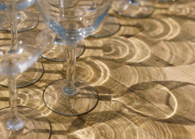 glassware reflecting sunlight on wooden table