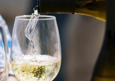 white wine pouring into stemmed wine glass