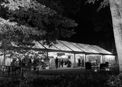 black and white photo of clear top wedding tent with twinkle lighting