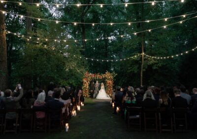 outdoor wedding ceremony with overhead lights suspended in trees