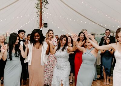wedding guests dancing under reception tent