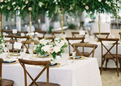 wedding tent set up on sand with crossback chairs and long guest tables
