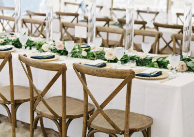 wedding reception tent set up with crossback chairs, and long banqet tables