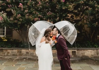 bride and groom kissing under clear umbrellas at winterthur