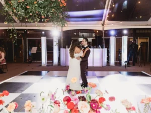 first dance on a black and white checkered dance floor under a cleartop tent at winterthur