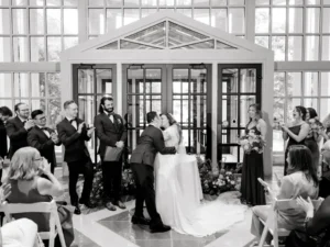 bride and groom kiss at indoor ceremony at winterthur