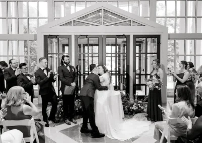 bride and groom kiss at indoor ceremony at winterthur