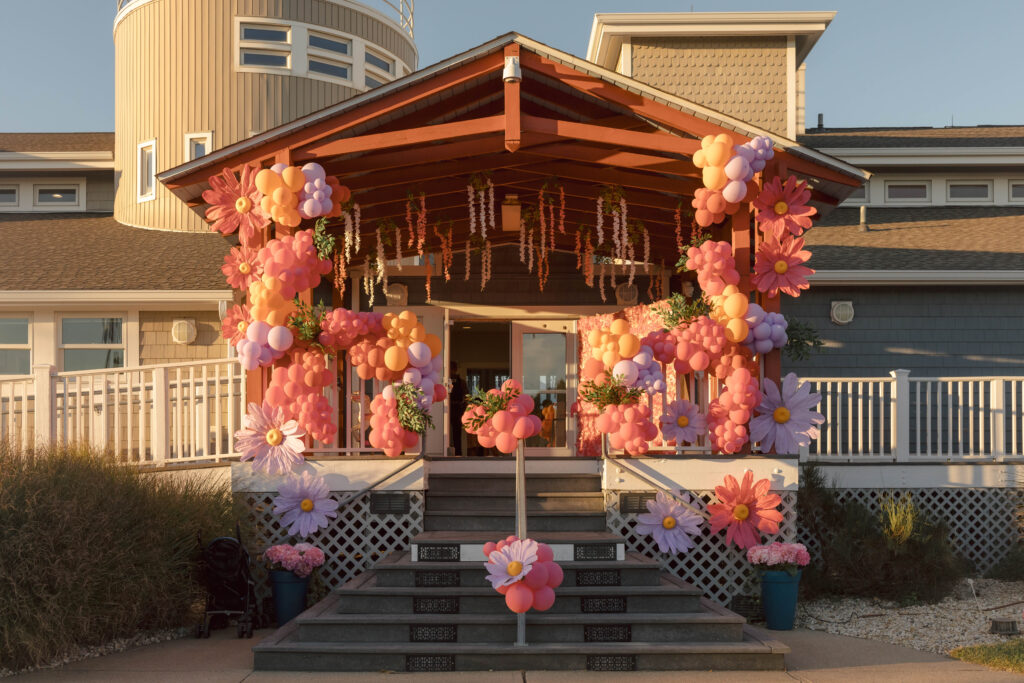entrance into building decorated with pink themed balloons