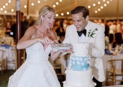bride and groom under wedding tent cutting their wedding cake