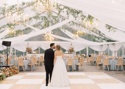 bride and groom standing under their wedding tent