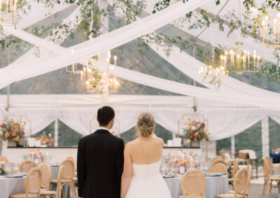bride and groom standing under their wedding tent