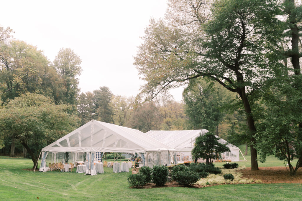 clear top tents set on green grass surrounded by trees