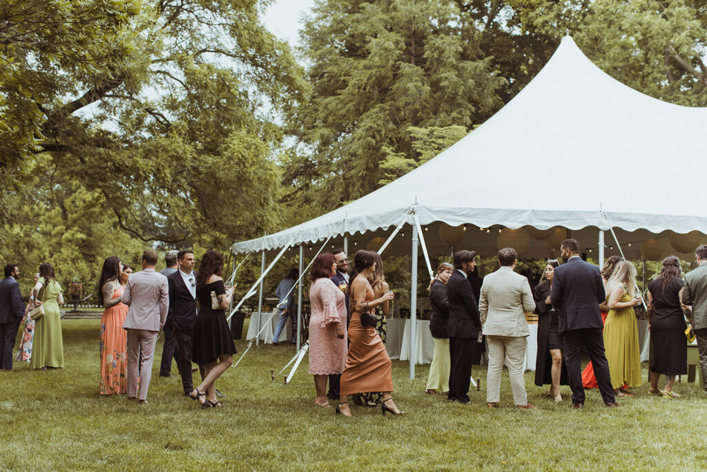 high peak pole tent on grass with people standing outside