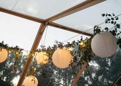 clear top tent with greenery and paper lanterns