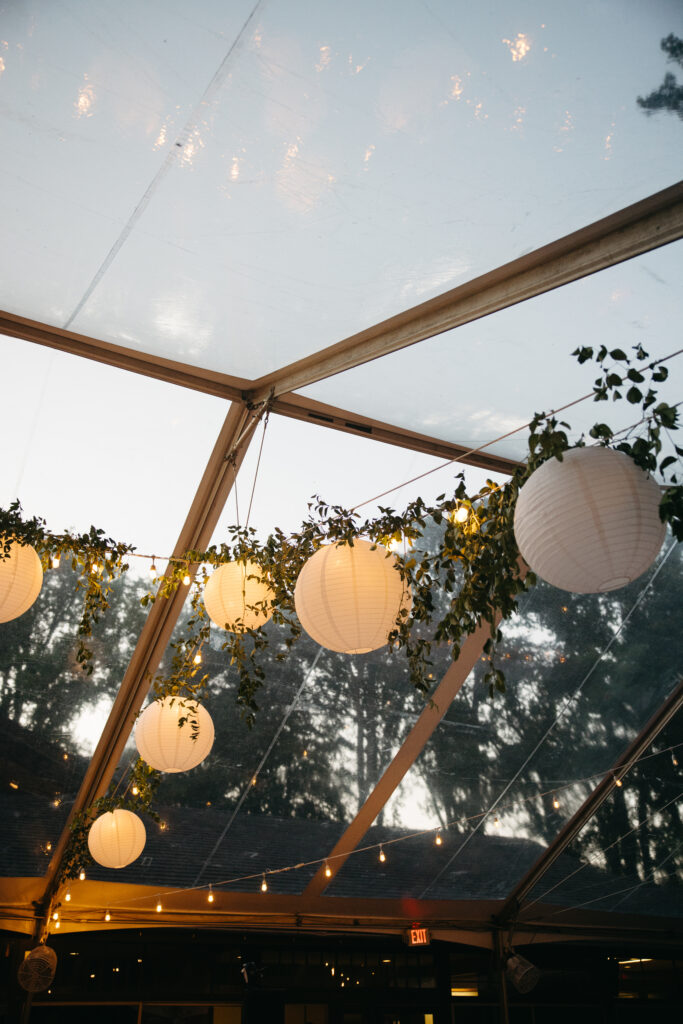 clear top tent with greenery and paper lanterns